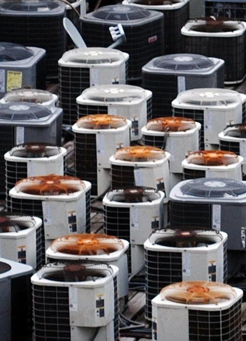 A rooftop crowded with air conditioning condenser units.